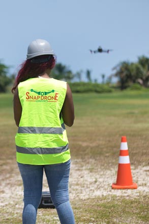 une pilote en formation drone professionnel au gabon portant un gilet de sécurité jaune